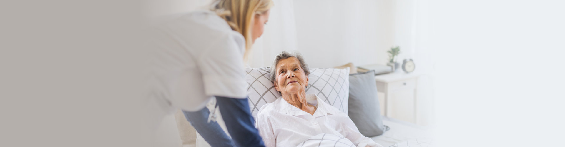 senior woman in bed with her caregiver