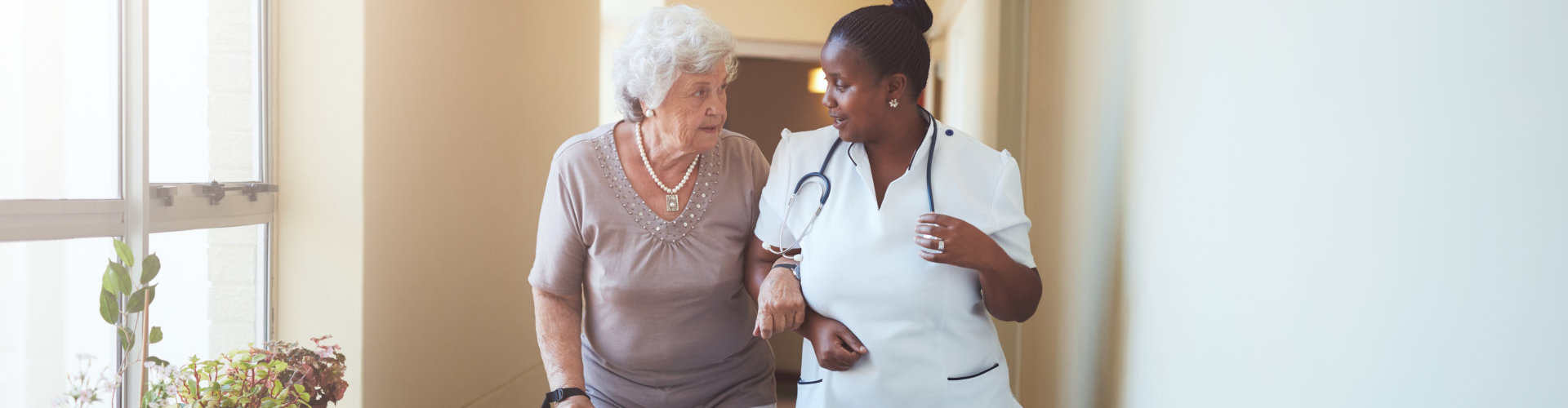 senior woman walking with her caregiver